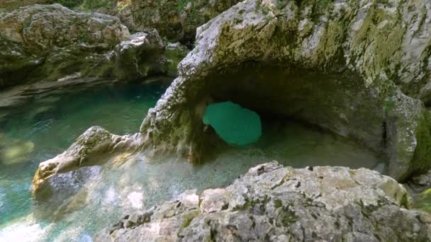 CERRAR: Agua cristalina de manantial que fluye lentamente más allá de grandes rocas musgosas . — Vídeos de Stock