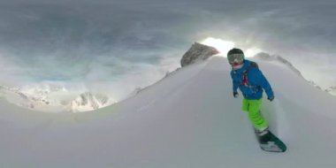 SELFIE Snowboard 'cu adam dağdan aşağı inerken kameraya kar püskürtür.