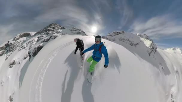 Žena narazí do muže, jak se snowboard ve zasněžených skalách. — Stock video