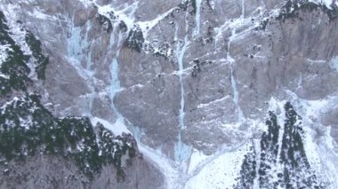 Donmuş nehirler Slovenya 'daki karlı bir dağın yamaçlarından aşağı dökülüyor.