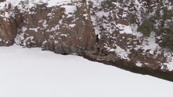 AERIAL: Volando hacia dos viajeros tomando un chapuzón en primavera en el nevado Colorado — Vídeo de stock