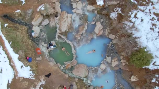 ARRIBA: Volando por encima de los turistas tomando un baño relajante en aguas termales en Utah. — Vídeo de stock