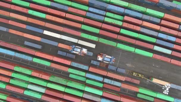 TOP DOWN: Vliegen boven industriële voertuigen verplaatsen van vrachtcontainers rond de haven — Stockvideo