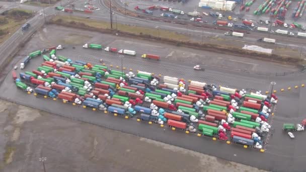 AERIAL: Vliegen boven een groep vrachtwagens die geparkeerd staan en wachten om vracht te lossen. — Stockvideo