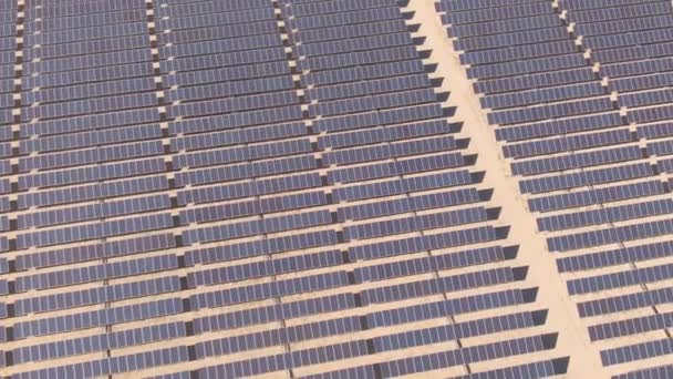 AERIAL: Leeg pad leidt door zonnepanelen elektriciteitscentrale diep in de woestijn — Stockvideo