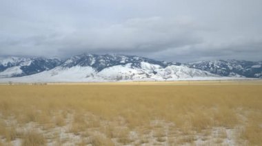Soğuk kış rüzgarları, bulutlu bir günde Montana 'nın manzaralı ovalarında eser..