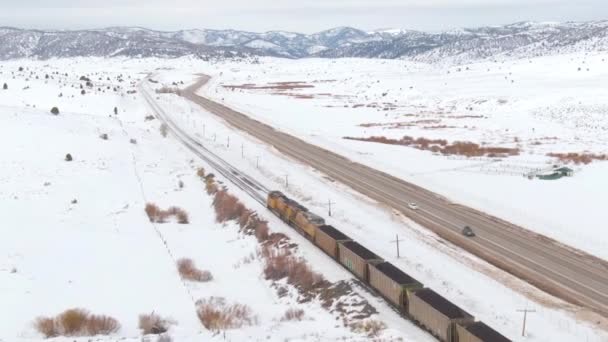 AERIAL: Cinematic skott av ett tåg som transporterar kol över hela landet på vintern. — Stockvideo