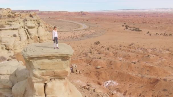 Jonge vrouwelijke reiziger staat op een klif en observeert de canyon.. — Stockvideo