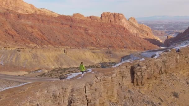 AERIAL: Flying bag en kvindelig fotograf trekking langs en sandsten formation – Stock-video