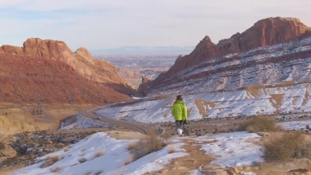 DRONE: Dişi gezgin kanyonu geçen otoyola bakan patika boyunca yürür — Stok video