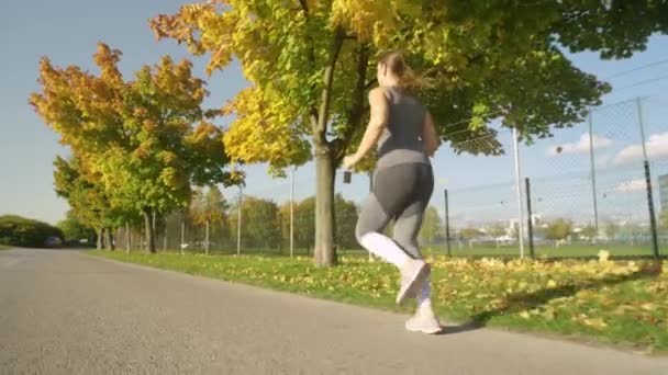 ESPACIO DE COPIA: Fotografía cinematográfica de una mujer corriendo por la pintoresca avenida de color otoño. — Vídeo de stock