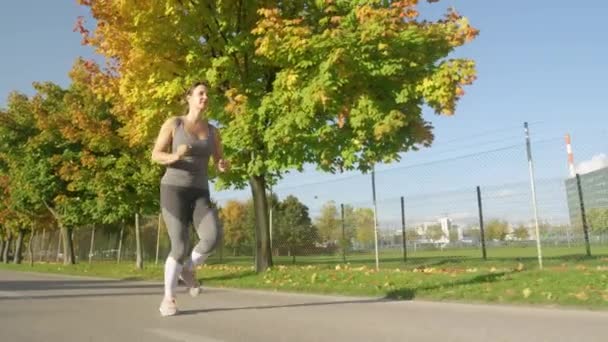 ESPACE DE COPIE : Une jeune femme profite d'une course relaxante à travers le parc le jour ensoleillé d'automne . — Video