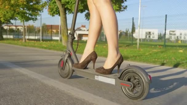 CLOSE UP: Modern affärskvinna pendlar för att arbeta på en cool elektrisk skoter. — Stockvideo