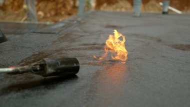 Kaynak makinesini yakmak beton temeli kaplayan katranı yavaşça eritir..