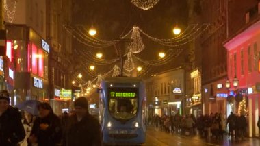 Pedestrianlar, tramvay şehirden geçmeden önce Zagreb 'de neşeli bir caddeden geçiyorlar