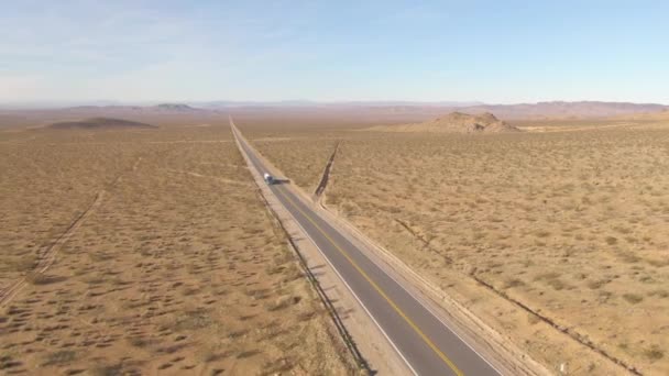 AERIAL: Big Rig arrastra una cisterna a través del escarpado desierto de Mojave en un día soleado. — Vídeo de stock
