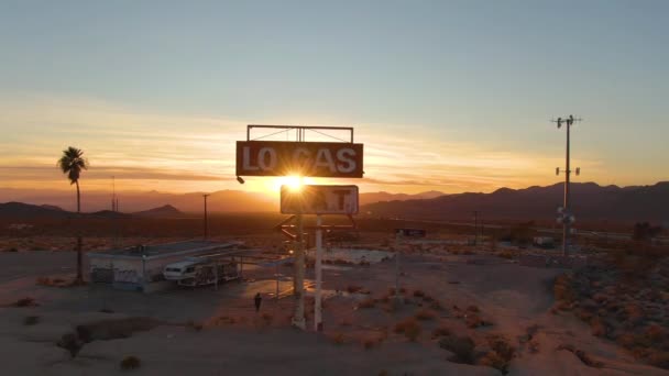 AERIAL: Onherkenbare fotograaf verkent verlaten tankstation bij zonsondergang. — Stockvideo