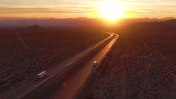 Napkeltekor egy teherautó mögött repül végig a Mojave autópályán. — Stock videók
