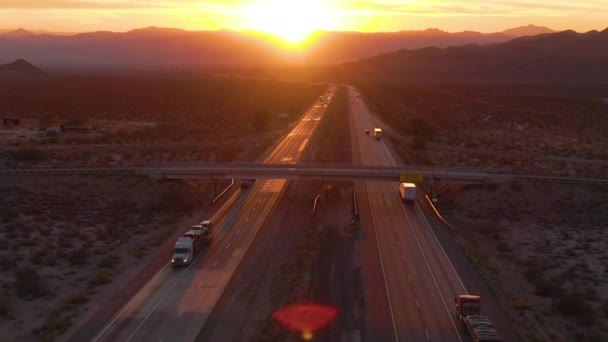 AERIAL: Autók és teherautók átkelnek a Mojave sivatagon egy napos nyári reggelen. — Stock videók