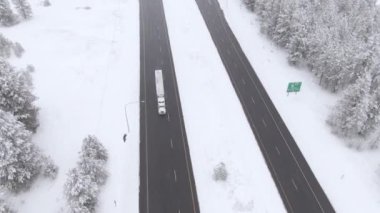 Kar fırtınası sırasında kaygan otoyolda hızla giden bir kamyonun üzerinde uçmak..