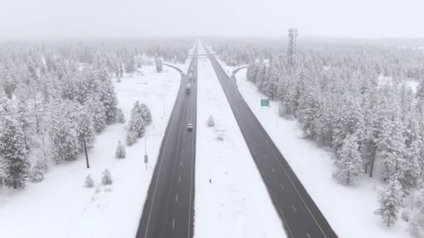 Lastbilar och bilar kör längs en våt motorväg i en snöstorm.. — Stockvideo