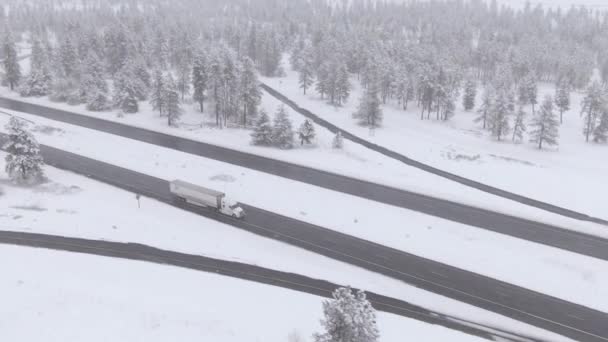 AÉRIAL : Grand camion commercial tire un conteneur lourd le long de la route glacée dangereuse — Video