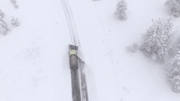 AERIAL: repülő felett egy hóeke teherautó tisztítása havas út a vidéki Amerikában. — Stock videók