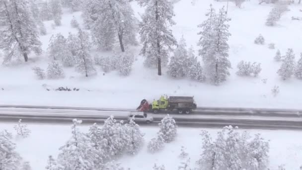 DRONE: Flying along a snow plough truck clearing a snowy road in rural America. — Stock Video