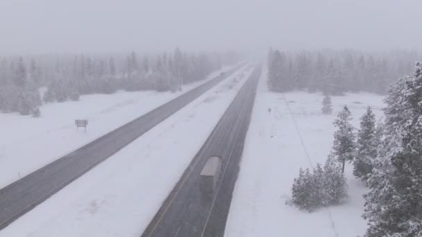 DRONE: Φορτηγό και αυτοκίνητα οδηγούν μέσα από τη χιονοθύελλα και κατά μήκος βρεγμένου αυτοκινητόδρομου. — Αρχείο Βίντεο