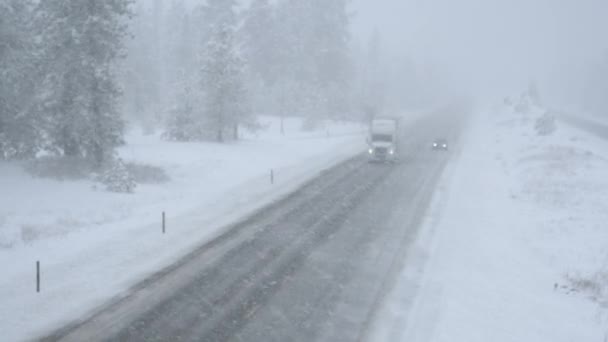 Półciężarówka i przejazd samochodem po śnieżnej drodze w okropnych warunkach pogodowych. — Wideo stockowe