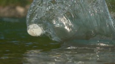 Nehrin yüzeyinden yansıyan yumuşak çakıl taşından sonra cam gibi su sıçrıyor..