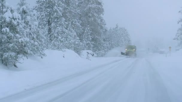 Κοντινό πλάνο: Φορτηγό οργώνει το χιονισμένο δρόμο χώρα κατά τη διάρκεια μιας φρικτής χιονοθύελλας. — Αρχείο Βίντεο