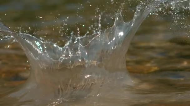 MACRO, DOF: Fotografía cinematográfica de guijarros cayendo en el frío arroyo reluciente. — Vídeo de stock