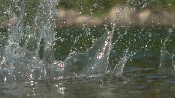 MACRO: Cênico tiro de água brilhante espirrando depois de seixo cai em um rio — Vídeo de Stock