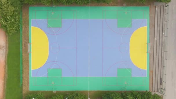 TOP DOWN: Widok z lotu ptaka na wielokolorowy plac zabaw w pustym parku sportowym — Wideo stockowe