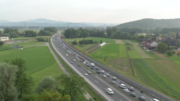 AERIAL: repül végig egy forgalmas autópálya tele csúcsforgalom egy napsütéses napon. — Stock videók