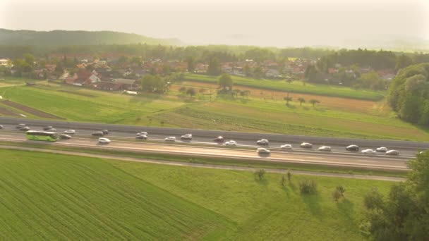 AERIAL: Raios de sol dourados de verão brilham em veículos presos em um engarrafamento na auto-estrada — Vídeo de Stock