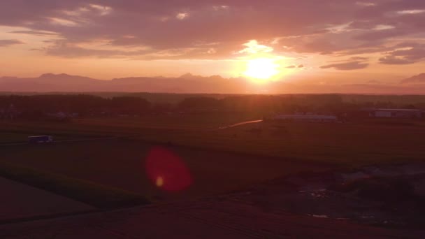 AÉRIAL : Coucher de soleil illumine la campagne pour les véhicules conduisant le long de la route panoramique . — Video