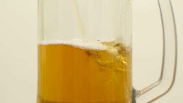 Verter cerveza en un vaso sobre fondo blanco. Moción lenta — Vídeos de Stock