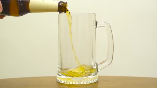 Bier gieten in een glas op witte achtergrond. Langzame beweging — Stockvideo