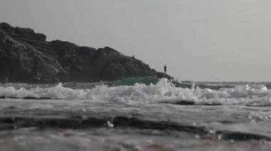 Balıkçılar kayalıklarda balık tutuyor..