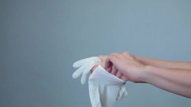 Kadın tek kullanımlık beyaz eldivenler giyer.