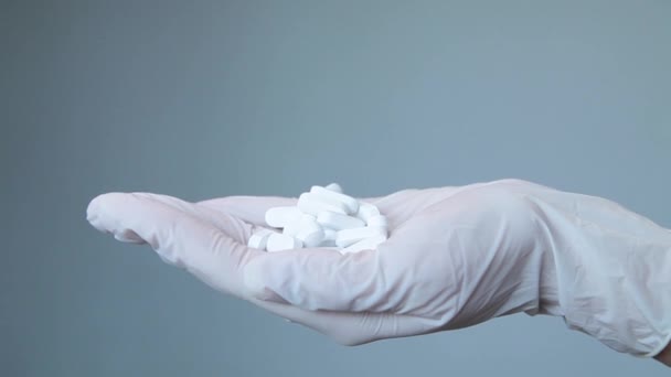 医療用手袋の女性は白い楕円形の丸薬を — ストック動画