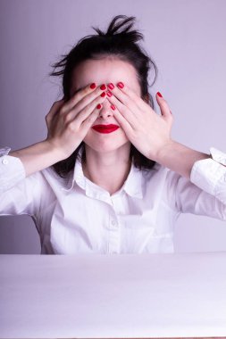 Dudaklarında kırmızı ruj lekesi olan beyaz arka planda beyaz gömlekli güzel bir genç kız.