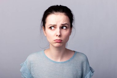 Gri arkaplan duygusuna sahip mavi tişörtlü güzel kız.