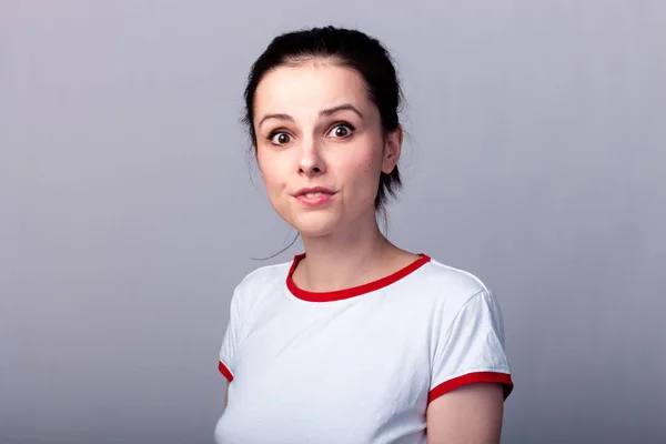 Atractiva Chica Emocional Una Camiseta Roja Blanca Sobre Fondo Gris —  Fotos de Stock