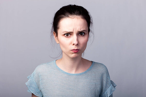 lovely girl in a blue t-shirt on a gray background emotion