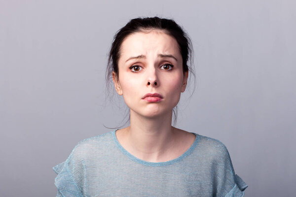 lovely girl in a blue t-shirt on a gray background emotion