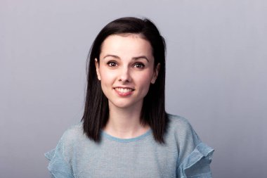 Gri arkaplan duygusuna sahip mavi tişörtlü güzel kız.