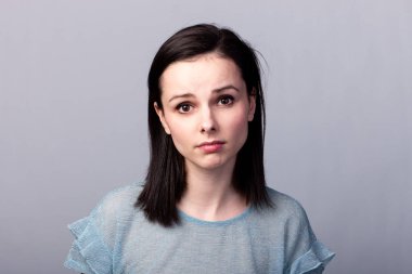 Gri arkaplan duygusuna sahip mavi tişörtlü güzel kız.
